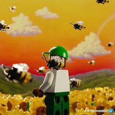 a lego man standing in the middle of a field with bees flying over him and looking at them