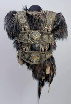 the back of a costume with feathers and buttons on it's chest, which is attached to a metal pole