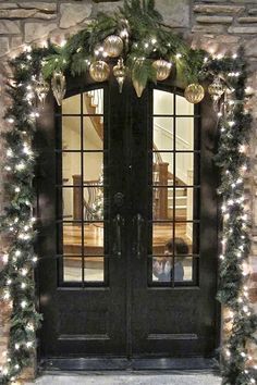 the front door is decorated with garland and lights