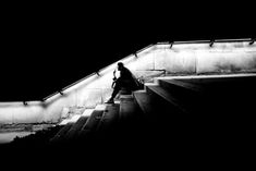 a person walking up some stairs in the dark with their hand on his hip bag