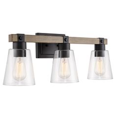 three light bathroom fixture with clear glass shades and wood accents on an aged metal finish