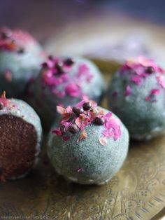 chocolate truffles with pink and purple sprinkles on a gold plate