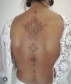 the back of a woman's neck with a lotus tattoo on it