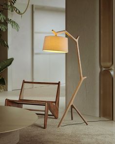 a wooden floor lamp next to a chair and table