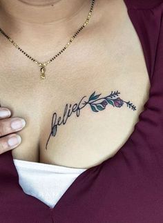 a close up of a woman's chest with the word believe tattooed on it