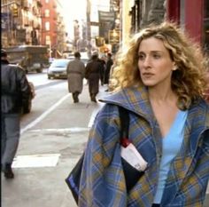 a woman is walking down the street wearing a coat