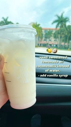 a person holding up a drink in front of a car window with the caption, vanilla syrup