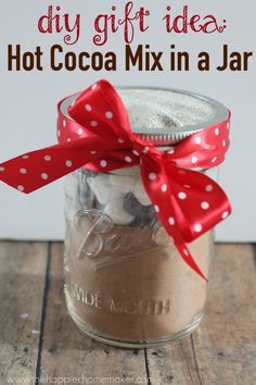 a glass jar filled with hot cocoa mix and a red ribbon tied around the top