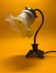 a lamp that is sitting on top of a yellow surface with a flower in the middle