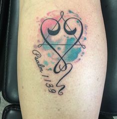 a tattoo on the leg of a person with a heart and two arrows in it