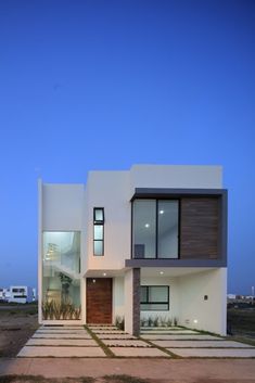 a modern house is shown at dusk with the sky in the background and grass on the ground