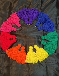 multicolored tassels arranged in the shape of a circle on a black background