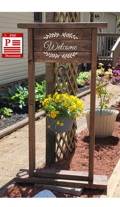 a wooden welcome sign with potted flowers