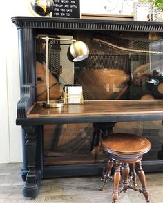 an old fashioned piano is on display in a store window with other items around it