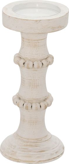 a white pedestal with a candle on top