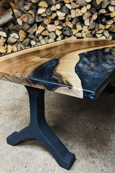 a wooden bench sitting in front of a pile of firewood on top of a floor