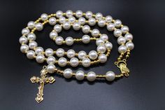 "This a classic beautiful Catholic rosary.  Pearls are a symbol of perfection and incorruptibility.  They symbolize long life and fertility.  Pearls also represent hidden knowledge and are very feminine.  This a wonderful gift for any woman or to yourself.  For every rosary sold, 1 will be donated to a catholic in need. Catholic rosarys are for prayer. Handmade in the USA Comes with a gift pouch Length = 21\" Weight = 3.0 oz" Elegant Gold Rosary For Gift, Elegant Gold Rosary As Gift, Gold Rosary With 8mm Beads For Meditation, Elegant Rosary With 8mm Beads And Crucifix, Adjustable Elegant Crucifix Rosary, Elegant Adjustable Crucifix Rosary, Elegant Rosary Bracelet With Cross For Gift, Elegant Adjustable Rosary With Crucifix, Elegant Cross Rosary Bracelet As Gift