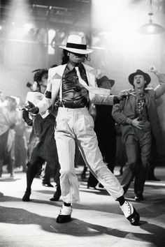 a man dressed in white and blue dancing