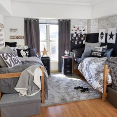 a bedroom decorated in black and white with grey bedding