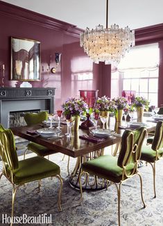 a dining room with purple walls and green chairs