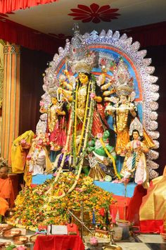 an idol is displayed in the middle of a room with other decorations and people around it