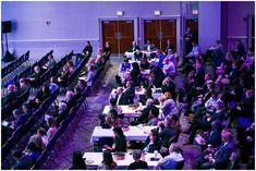 a large room filled with people sitting at tables