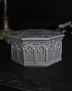 a white box sitting on top of a table next to a candle and some flowers