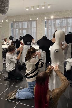 several people working on mannequins in a room