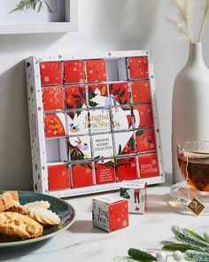 a table topped with cookies and tea next to a white vase