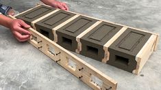 two hands are holding the bottom part of a wooden pallet that is being constructed