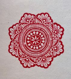 a red and white paper with an intricate design on it