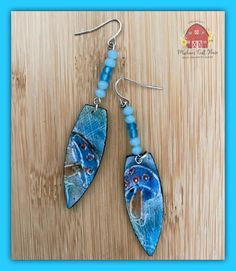 Magical Blue Mushrooms 🍄 💙 $36 Artisan made, dagger-shaped, clay, earring components, depicting, shades of blue mushrooms, hangs from silver plated ear wires, with matching blue glass beads.  These lightweight earrings are 2 1/4" long. One earring weighs 2.0g. Unique Blue Long Drop Jewelry, Whimsical Blue Drop Earrings, Artistic Blue Czech Glass Jewelry, Whimsical Blue Nickel-free Earrings, Whimsical Hand Painted Blue Earrings, Whimsical Blue Hand Painted Earrings, Artsy Blue Dangle Earrings, Artsy Nickel-free Blue Jewelry, Artsy Blue Nickel-free Jewelry