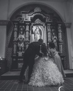 a bride and groom are kissing in front of the alter