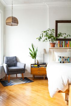 a bed room with a neatly made bed and a chair