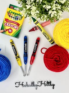 crochet supplies laid out on a white surface with flowers and yarn in the background