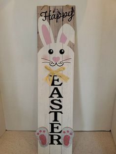 a wooden sign with the words happy easter painted on it and an image of a bunny