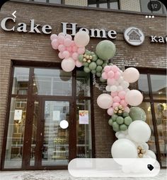 the entrance to cake home is decorated with pink, green and white balloons in front of it