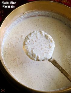 a ladle full of milk being stirred by a wooden spoon in a metal bowl