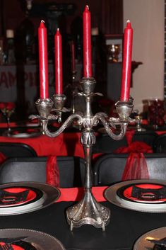 a candelabra with red candles on top of it in a dining room