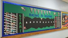 a bulletin board with race themed writing on the front and back wall in a school hallway