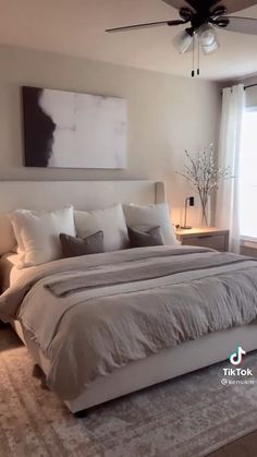 a large white bed sitting in a bedroom next to a window