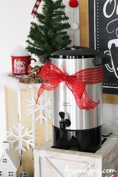 a small christmas tree sitting on top of a wooden box next to a crock pot