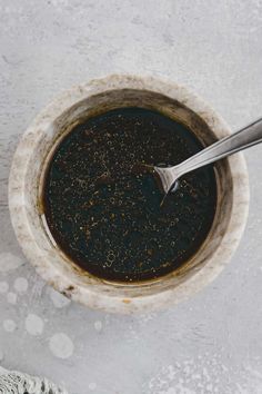 a spoon in a bowl filled with black liquid