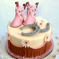 a cake decorated with pink and brown fondant boots and a cowgirl boot on top