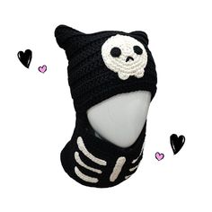 a knitted hat with a skull on it and hearts around the cap, all in black