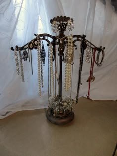 there is a jewelry stand with many necklaces on it and beads hanging from the top