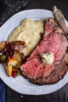 a white plate topped with steak, potatoes and gravy next to a fork