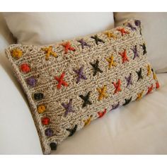 a crocheted pillow sitting on top of a white couch