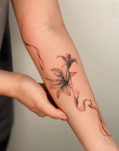 a woman's arm with a flower tattoo on it