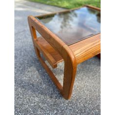 a wooden table with glass top sitting on the ground